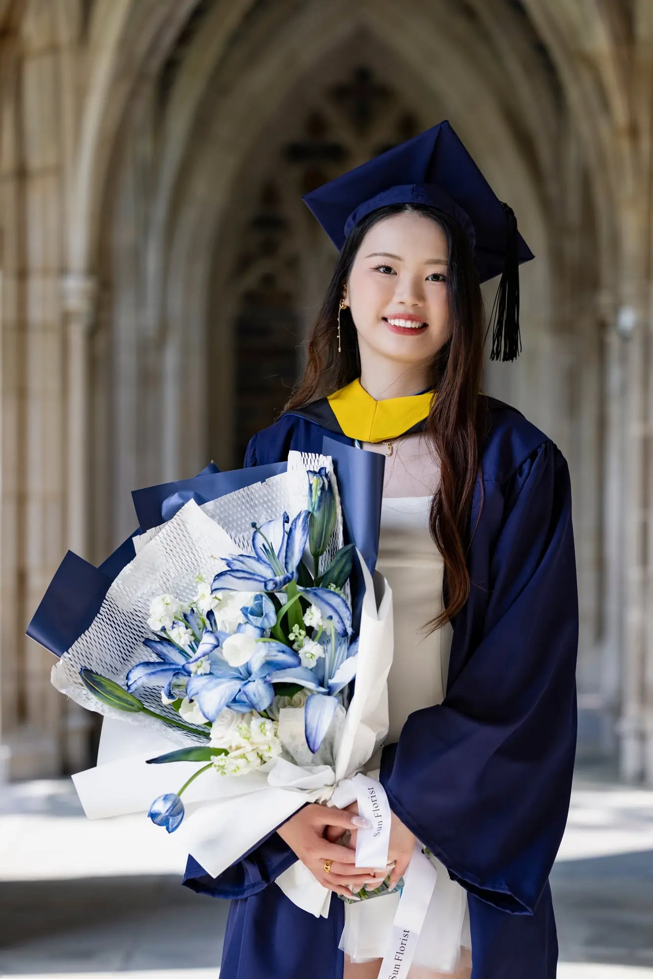 Wrapped in blue and white, this bouquet celebrates both growth and grace. Here’s to the next chapter, as radiant as you are.