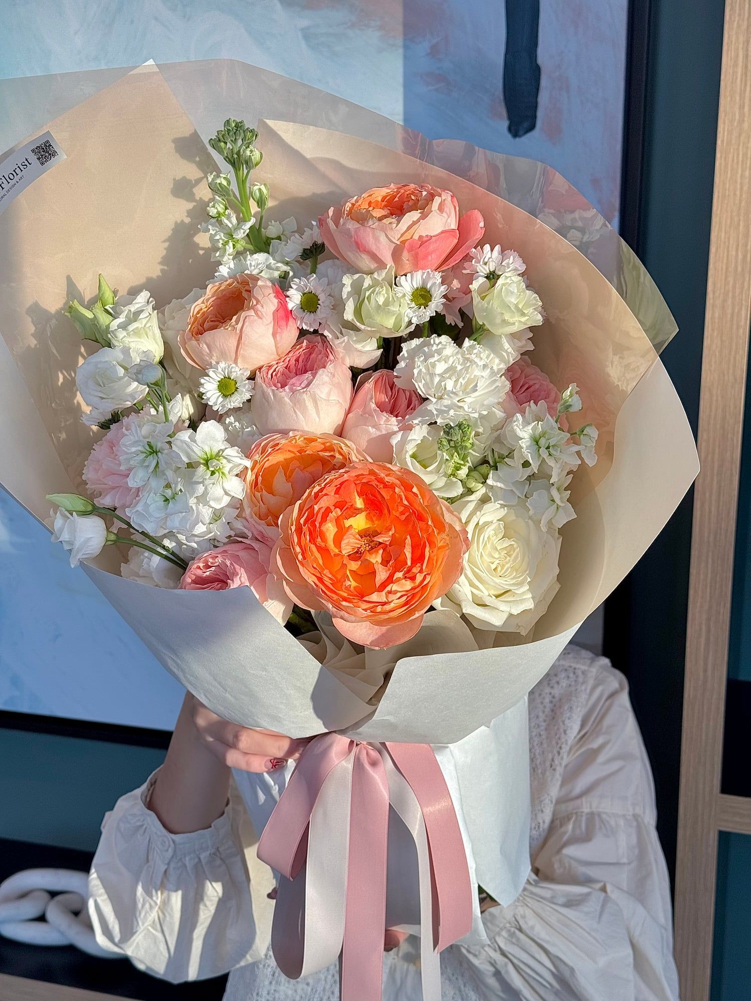 This orange-pink bouquet is like a gentle sunset casting its glow over soft coral. A perfect way to bring warmth and elegance into your space.