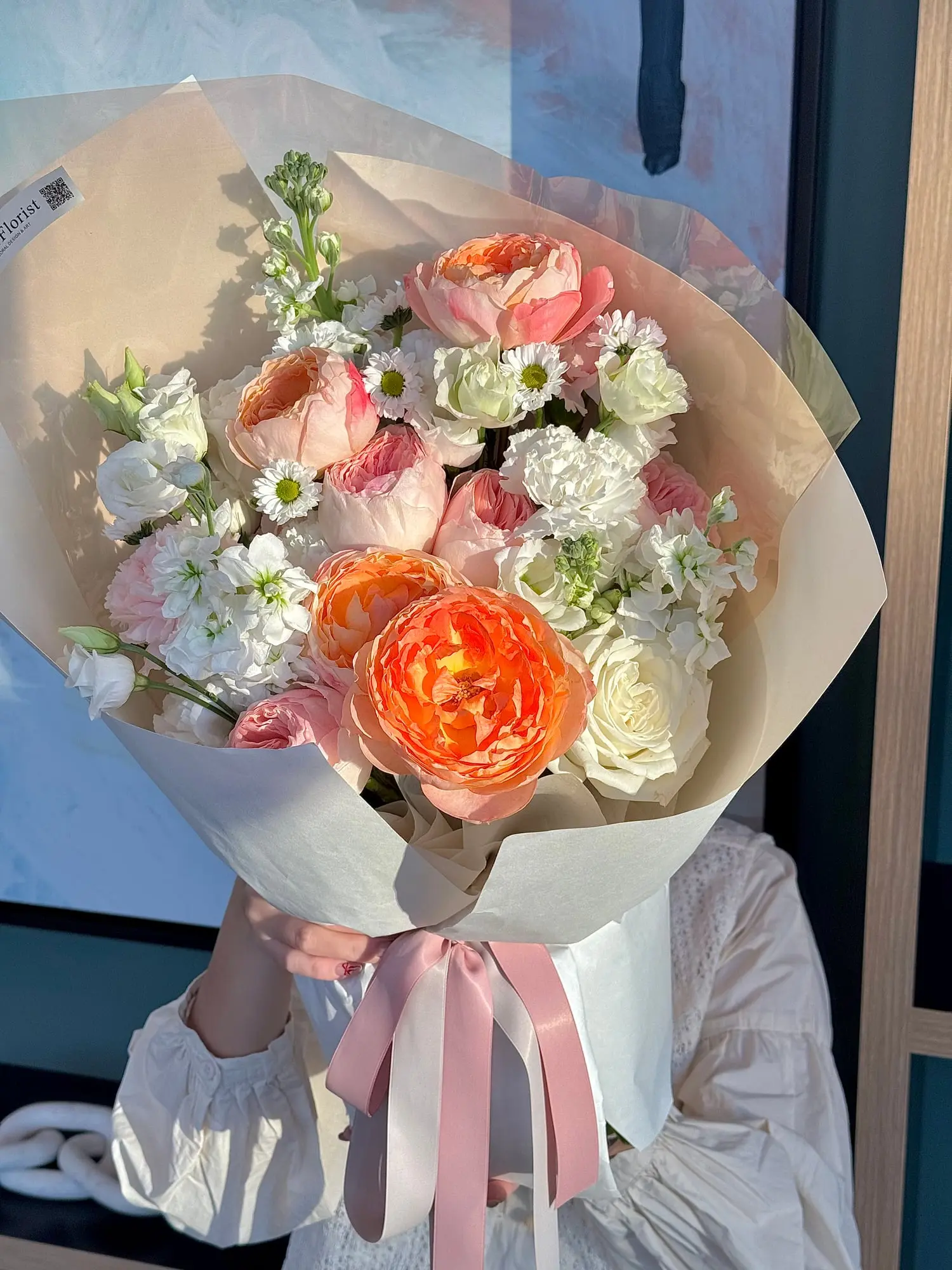 This orange-pink bouquet is like a gentle sunset casting its glow over soft coral. A perfect way to bring warmth and elegance into your space.