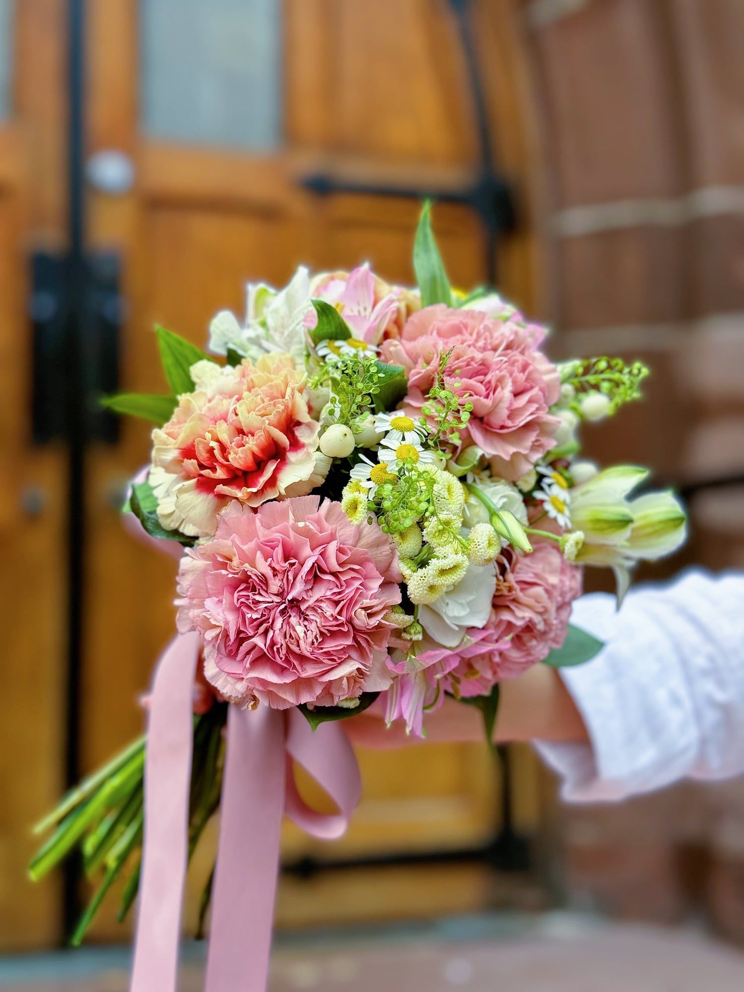 This romantic bouquet features lush pink carnations, delicate white blooms, and fresh greenery , creating a soft yet vibrant arrangement.