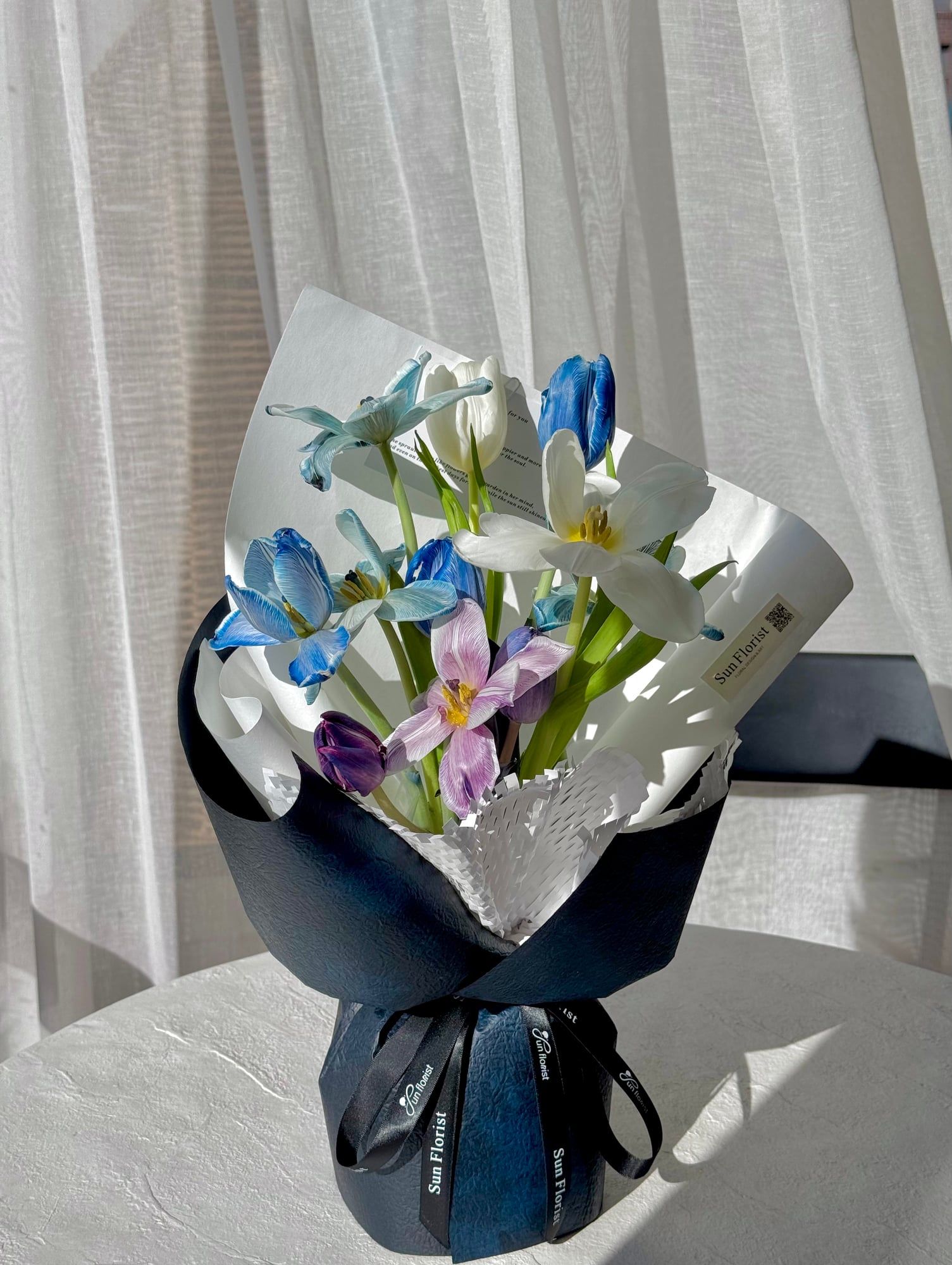 A breathtaking blend of blue and white tulips, this bouquet embodies elegance and serenity.