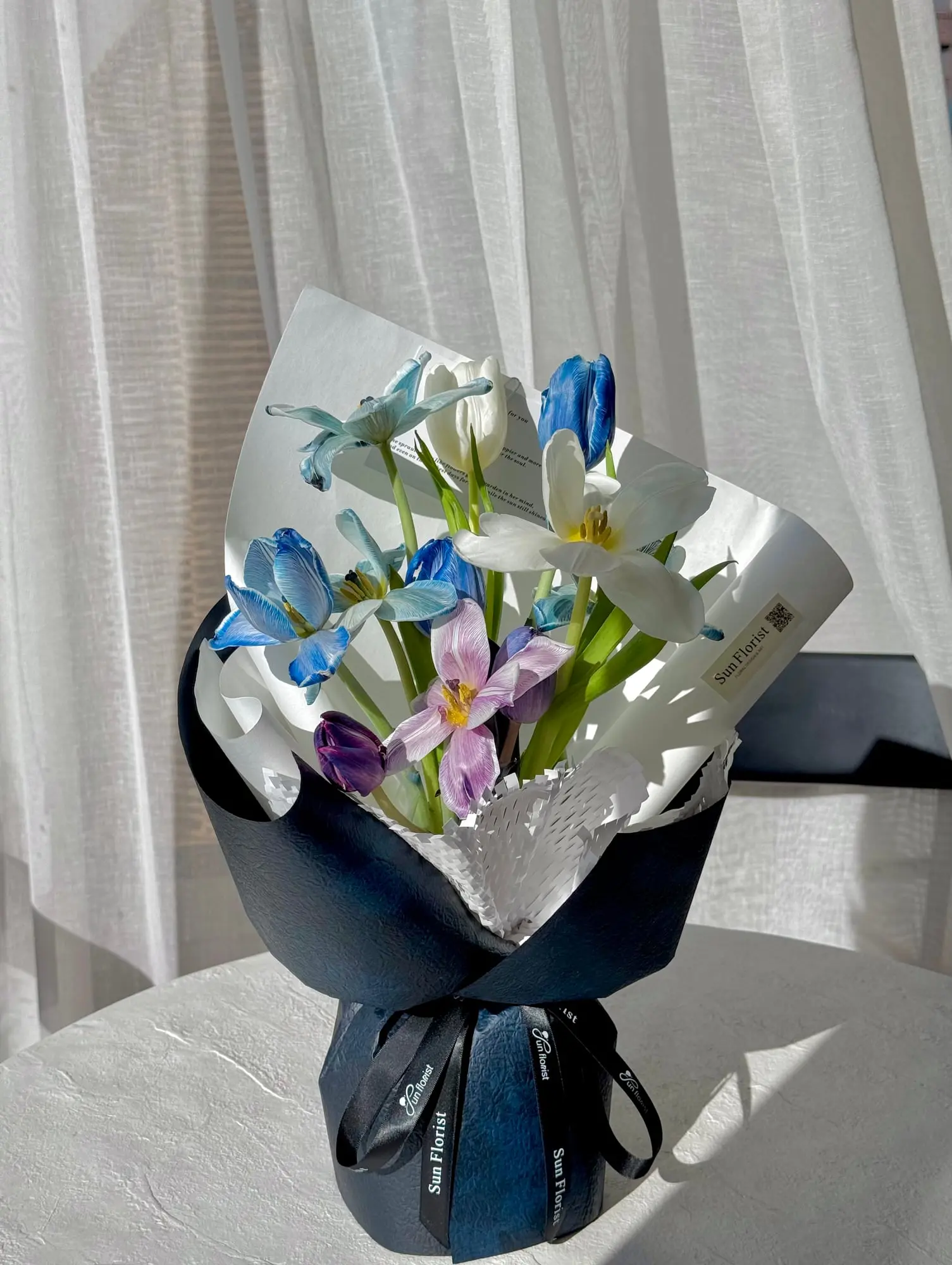 A breathtaking blend of blue and white tulips, this bouquet embodies elegance and serenity.