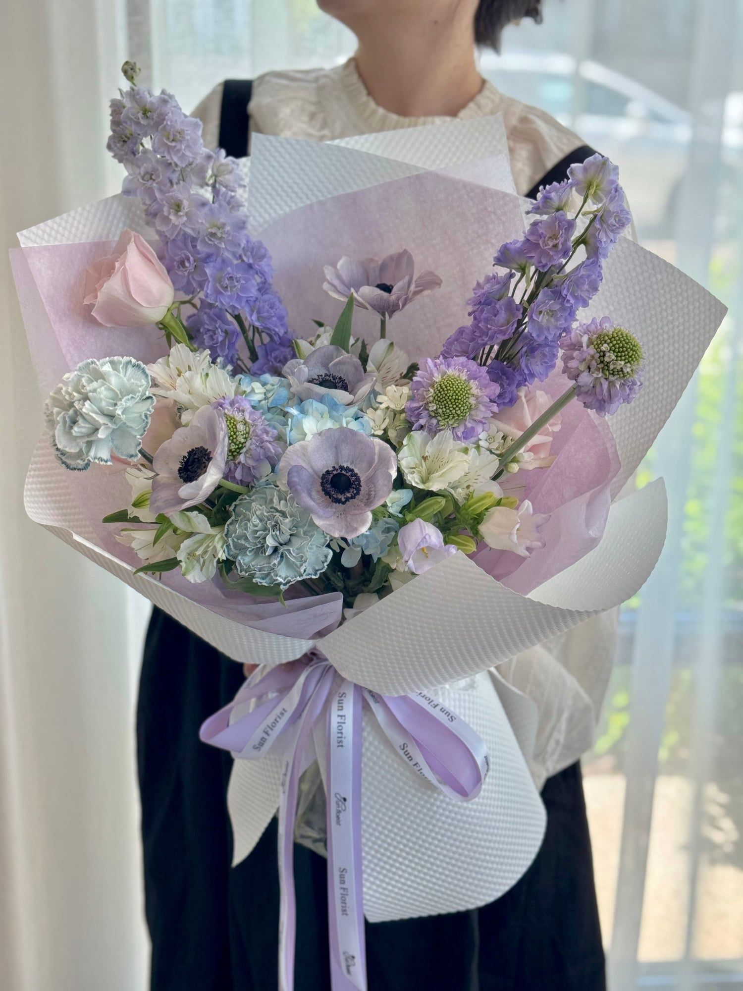 A dreamy palette of lavender, icy blue, and blush pink, composed like a delicate waltz. Anemones, carnations, delphinium—each bloom dances with grace and softness.
