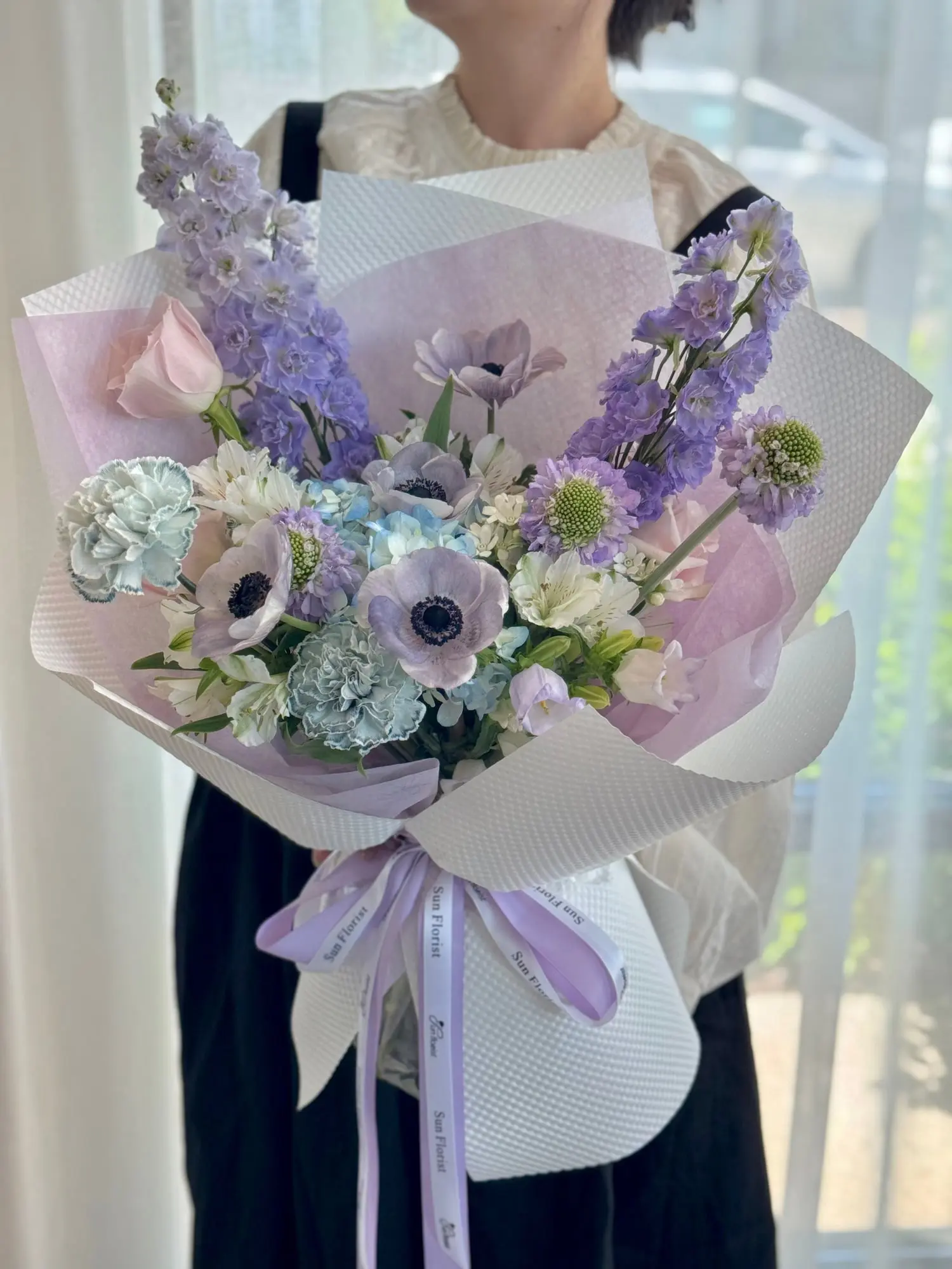 A dreamy palette of lavender, icy blue, and blush pink, composed like a delicate waltz. Anemones, carnations, delphinium—each bloom dances with grace and softness.