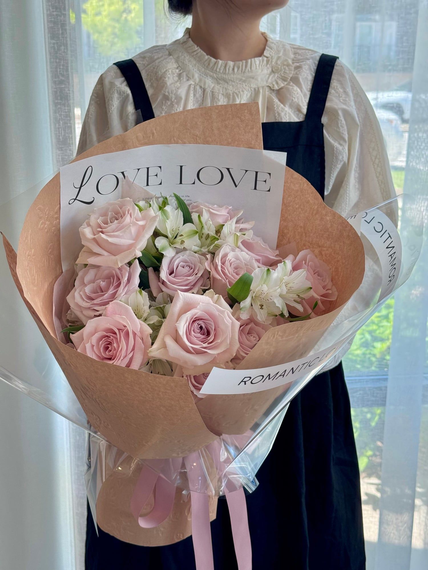 Soft blush roses and white alstroemeria, wrapped in warmth and a whisper of romance.