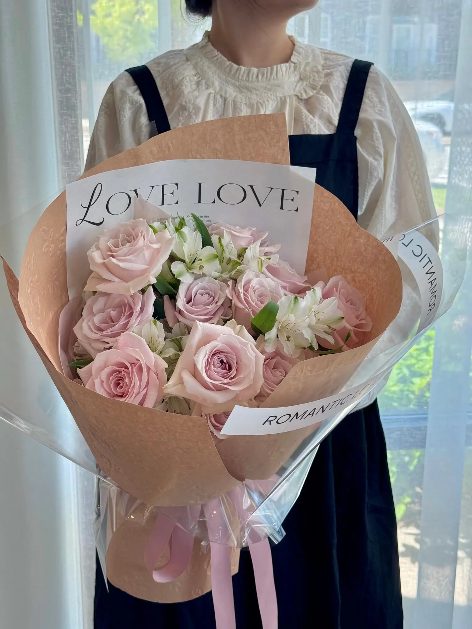 Soft blush roses and white alstroemeria, wrapped in warmth and a whisper of romance.