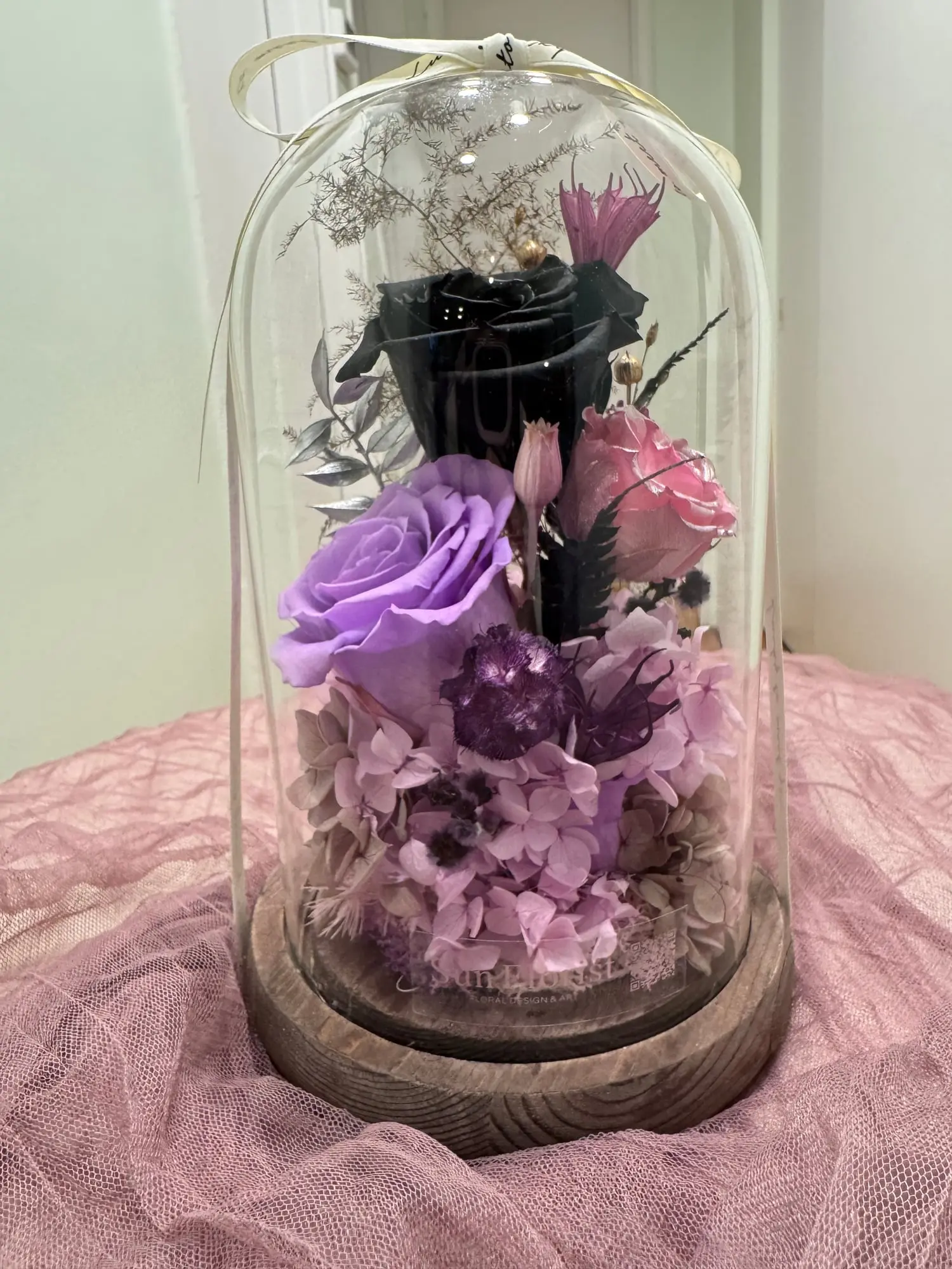 A preserved floral dome where mystery meets elegance.