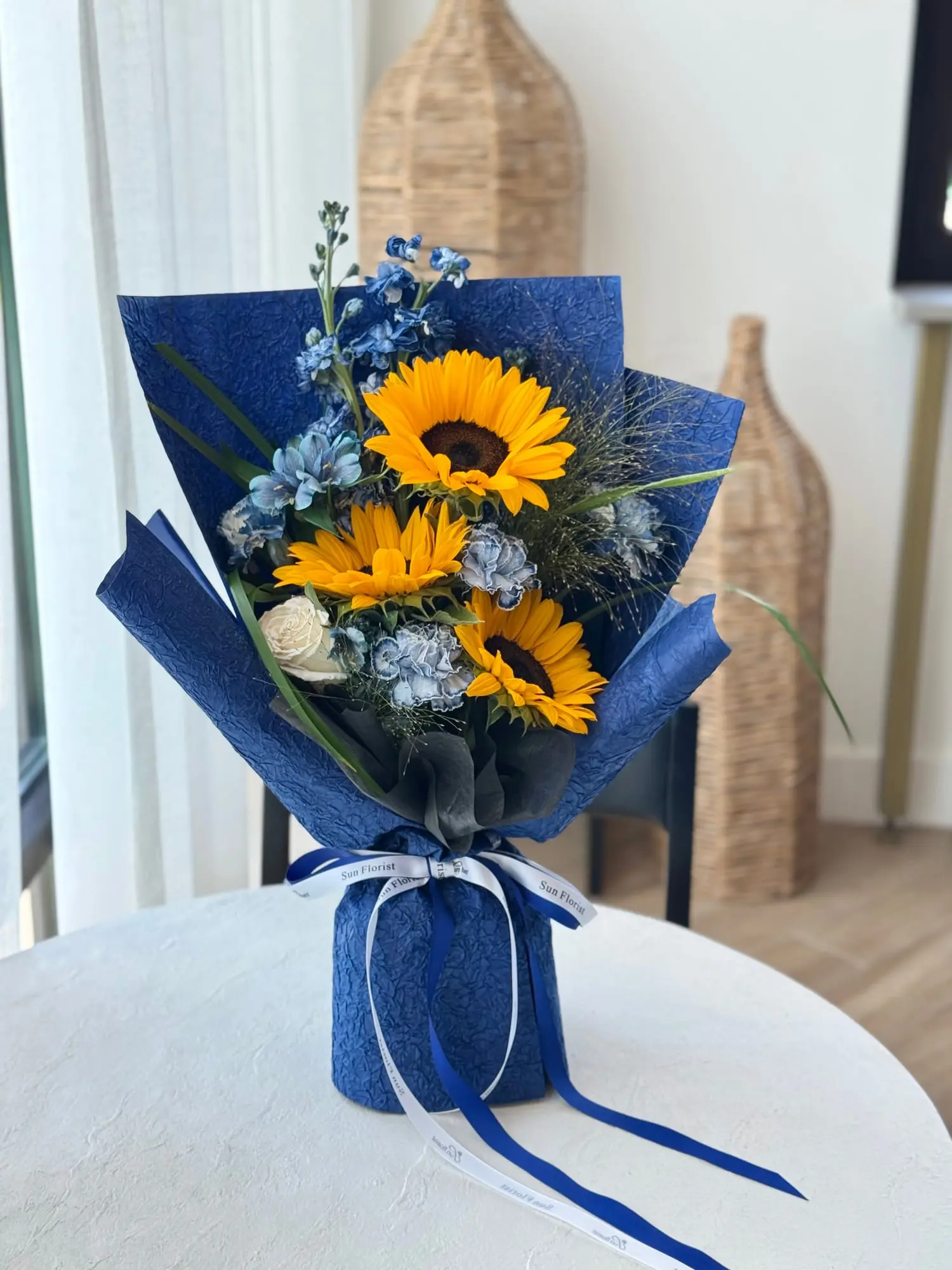 Sunflowers for strength, deep blue for wisdom. This bouquet speaks bold beginnings and bright futures. For the graduate, the dreamer, the doer.