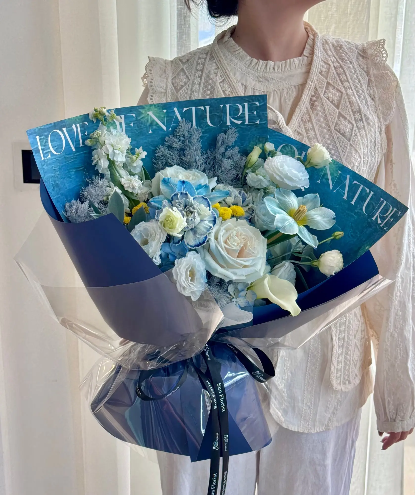 A bouquet drawn from the colors of the cosmos— deep sapphire, gentle ivory, bursts of yellow.